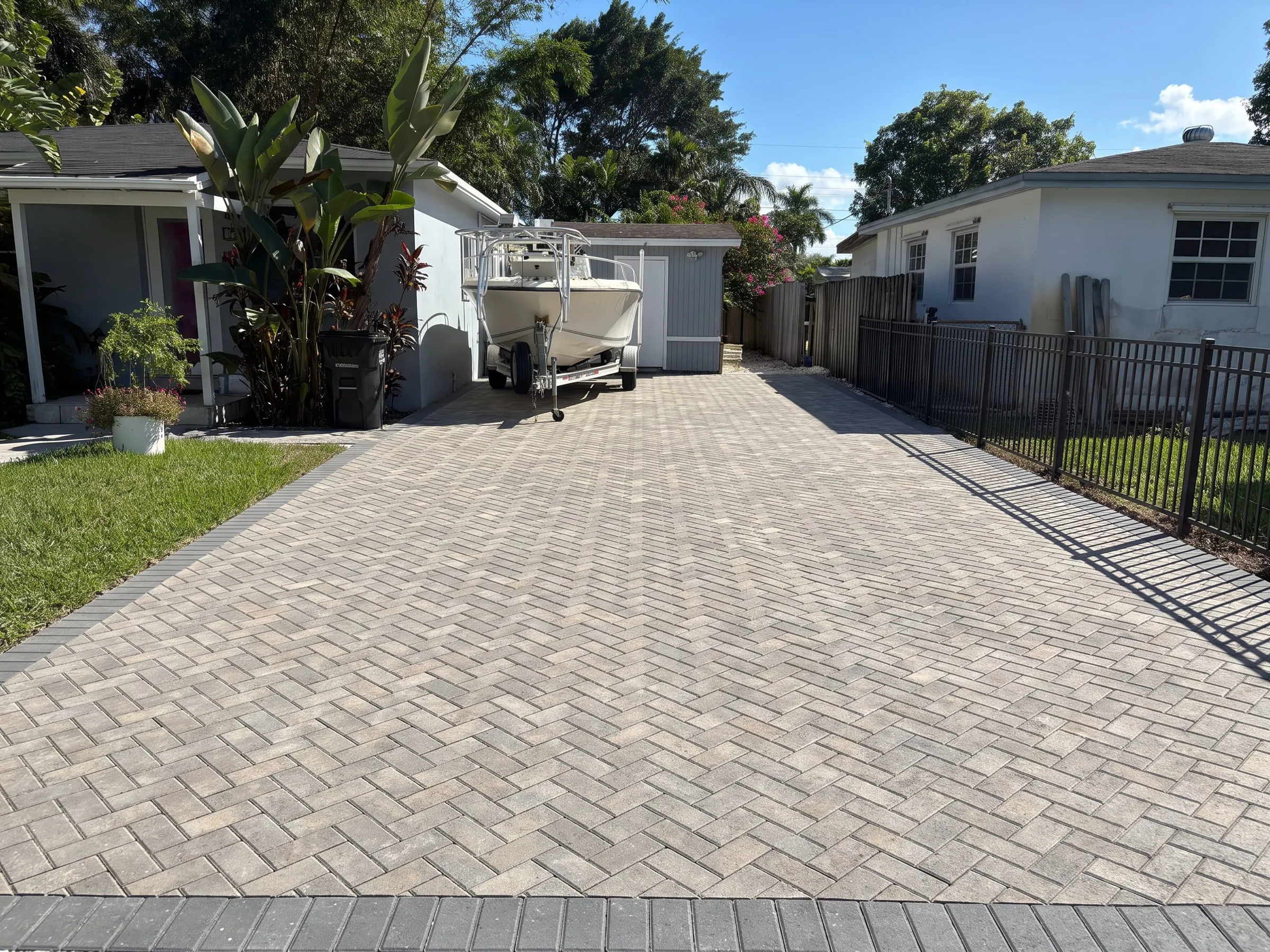 AI visualization of the same driveway finished in herringbone pavers with a charcoal border