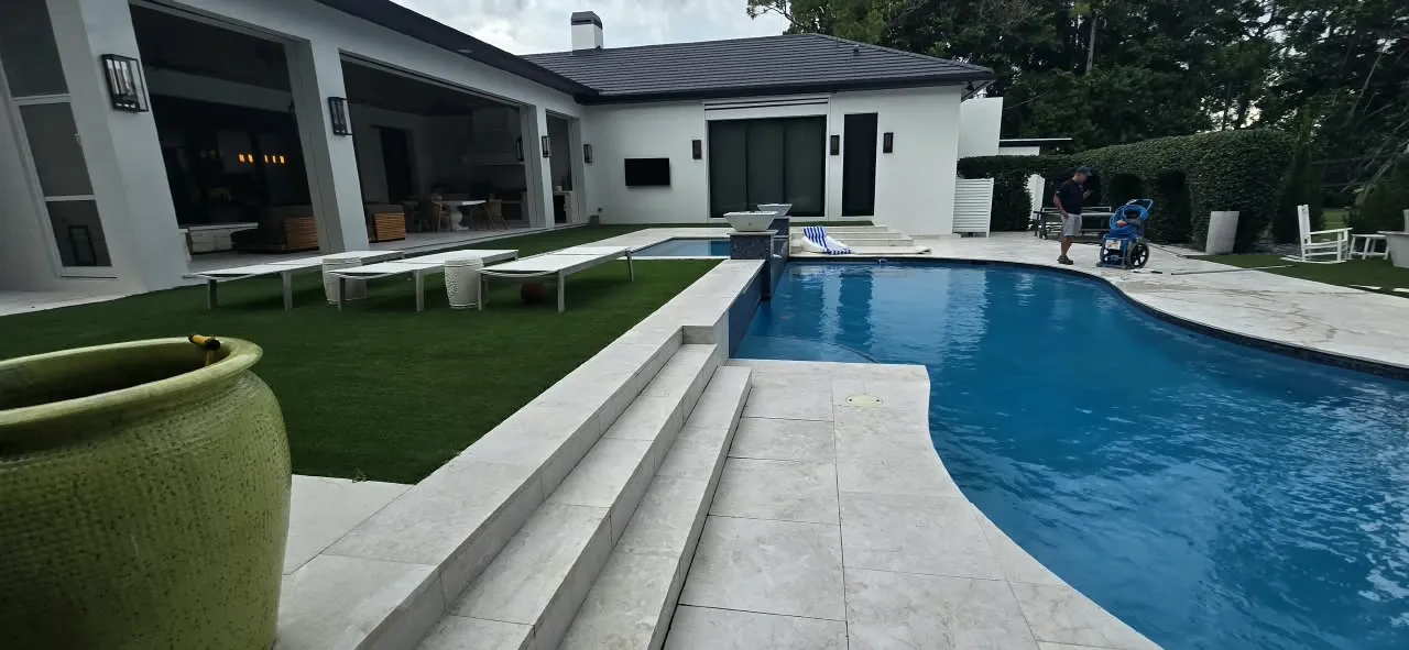 Modern pool and raised spa with turf-striped paver patio