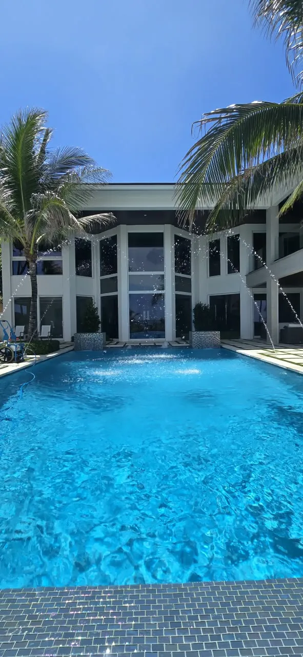 Oceanfront pool with fountain jets and glass-tile waterline