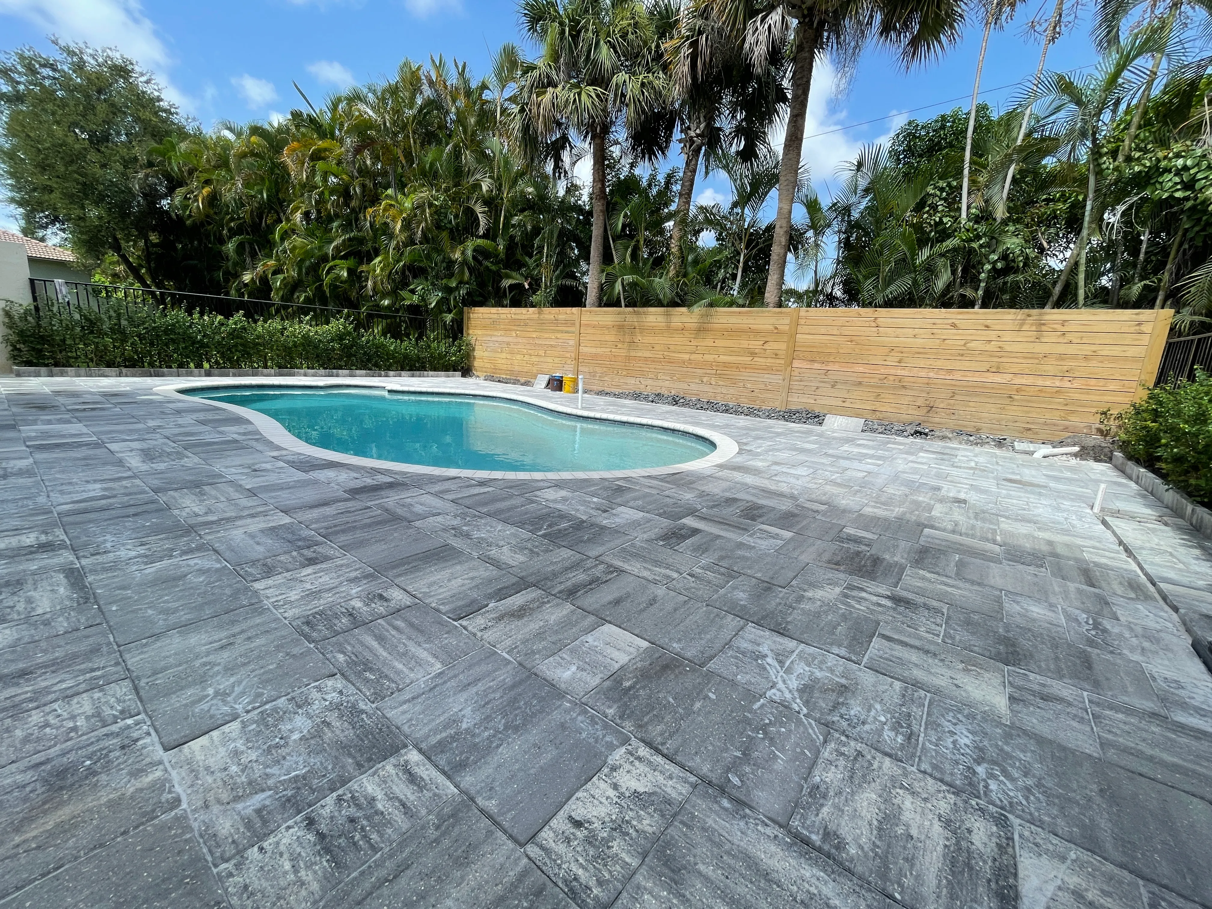Same pool after the deck renovation, finished in large-format grey pavers