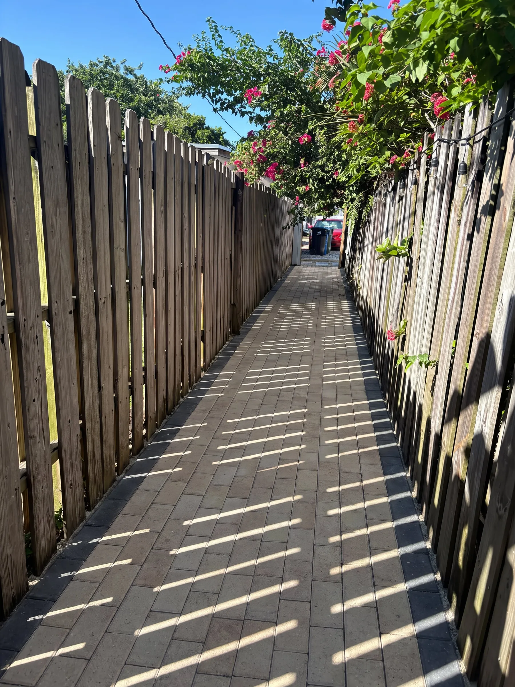 AI visualization of the same side yard paved wall to wall with sand-colored pavers